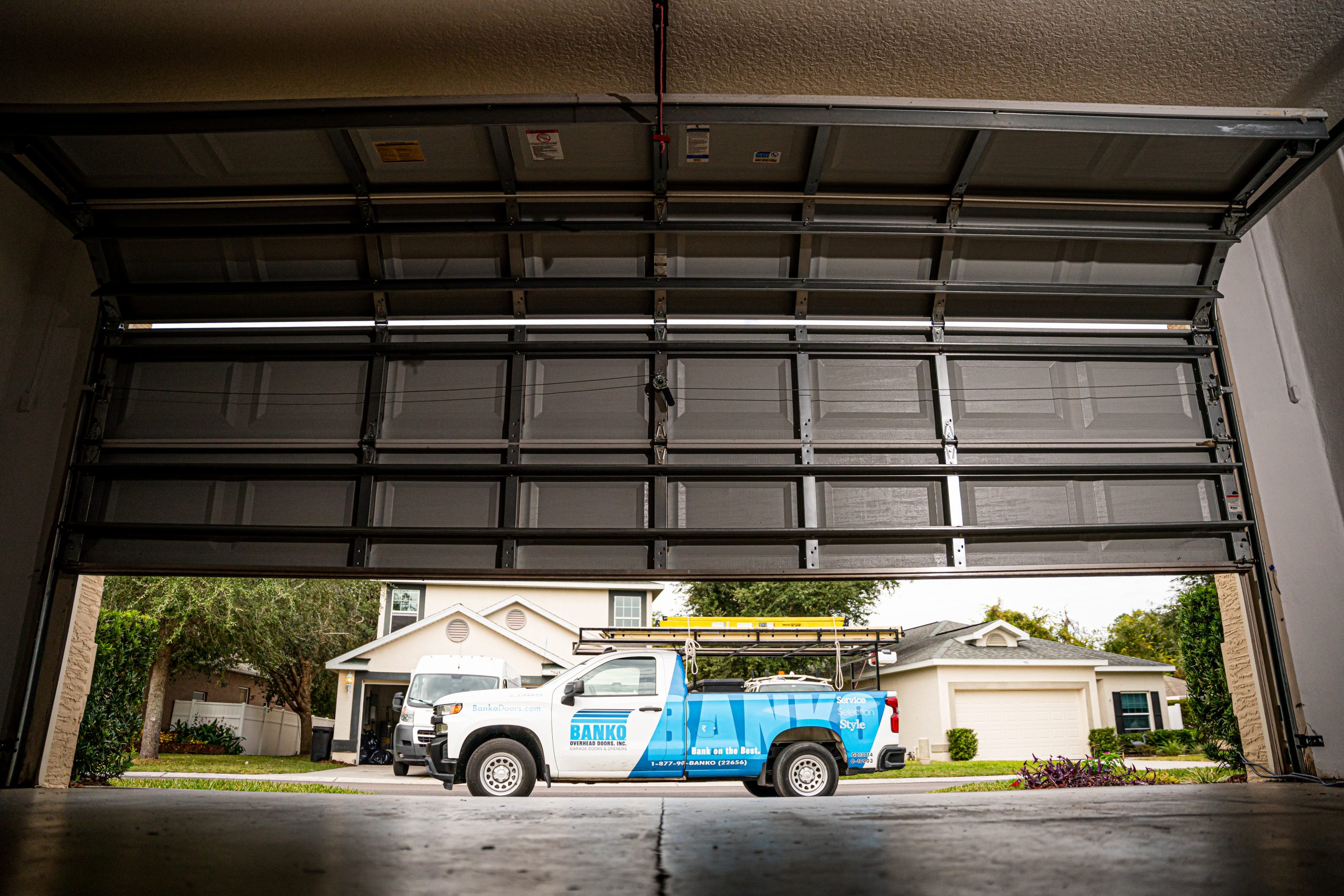 View of Banko Overhead Doors Service Truck through slightly opened garage door